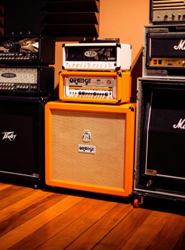 Row of colorful amplifiers in a music studio, showcasing diverse audio equipment.